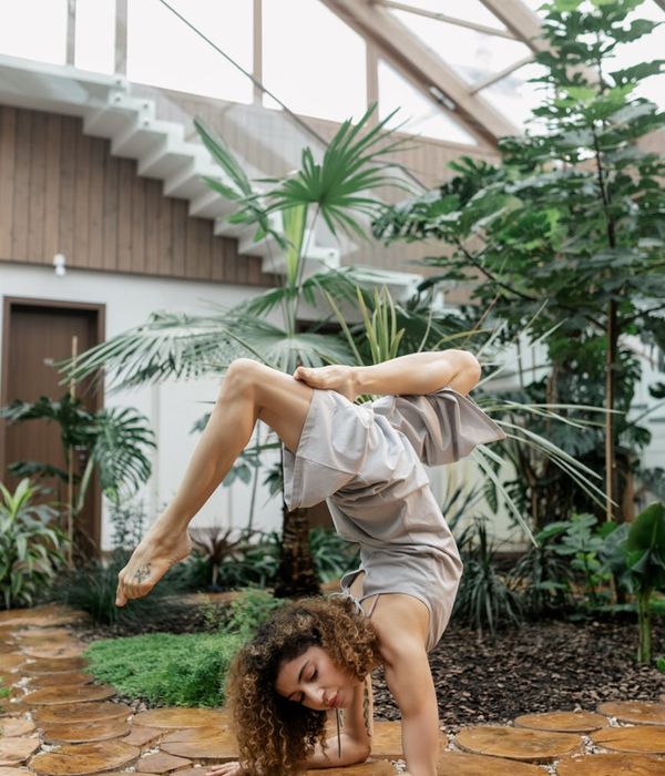 Woman in a graceful yoga pose with mint green light accents.